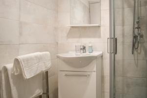 een witte badkamer met een wastafel en een douche bij La Dolce Vita in Potenza
