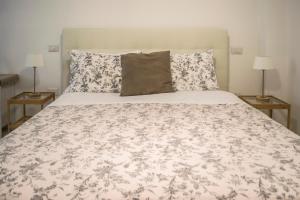 sypialnia z dużym łóżkiem z kocem i poduszkami w obiekcie La Dolce Vita w mieście Potenza