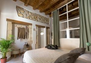 a bedroom with a large bed and a mirror at Ortigia Boutique Palace in Siracusa