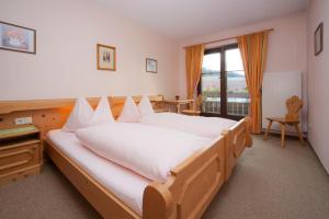 ein Schlafzimmer mit einem großen Bett und einem Fenster in der Unterkunft Café Rainer in Sankt Johann in Tirol