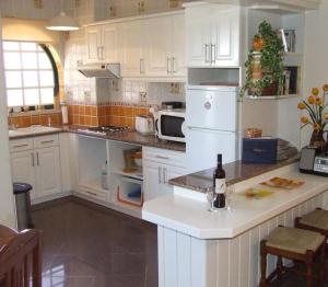 a kitchen with white cabinets and a counter with a bottle of wine at Vau Sea View, T2 Apartment, Close to Beach,Ideal for families in Portimão