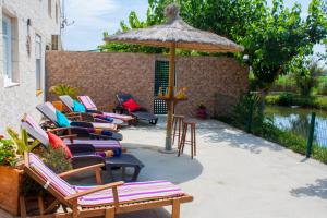 een groep stoelen en een parasol op een patio bij Paradise Ebro 2 in Deltebre