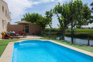 a swimming pool in a yard next to a house at Paradise Ebro 2 in Deltebre +44 photos