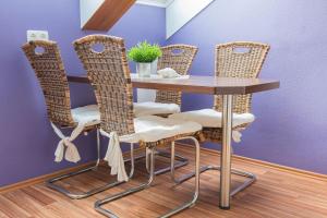 einen Tisch mit vier Stühlen und einen Tisch mit einer Pflanze in der Unterkunft Haus Meeresglück Wohnung Seestern in Dahme