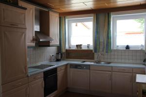 a kitchen with a sink and two windows in it at Ferienhof Pöhlmann in Wunsiedel