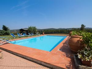 a large swimming pool with chairs and potted plants at Holiday Home Il Poggetto by Interhome in Mercatale Val Di Pesa