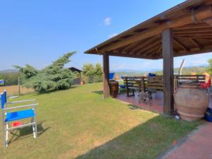 a gazebo with two benches and a dog under it at Holiday Home Il Poggetto by Interhome in Mercatale Val Di Pesa