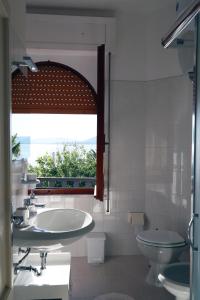 een badkamer met een wastafel en een toilet en een raam bij Eliton in Alghero +58 foto's