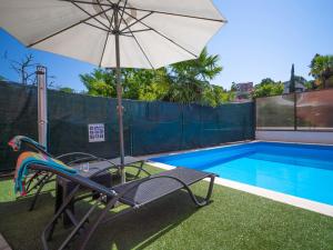 a chair and an umbrella next to a swimming pool at Apartment Sandra by Interhome in Matulji