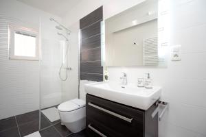 a bathroom with a sink and a toilet and a shower at Apartments Roso - Hvar in Hvar