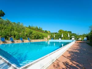 La CollinaにあるApartment Il Gelsomino by Interhomeのラウンジチェアとパラソル付きの大型スイミングプール