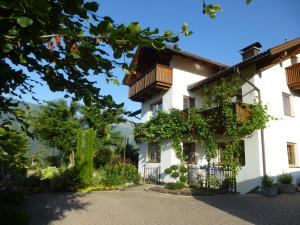 a white house with a balcony and flowers at Ferienwohnung Mayr in Thurn