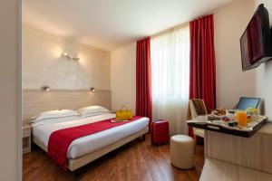 una habitación de hotel con una cama grande con cortinas rojas en Simon Hotel en Pomezia