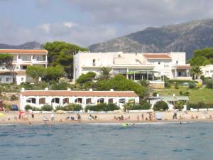 a group of people on a beach near the water at Apartamentos LLorca in Platja de l’Almadrava