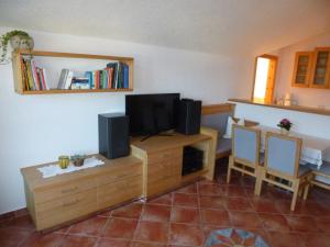 a living room with a television on a wooden dresser at Ferienwohnung Mayr in Thurn