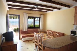 cocina y comedor con mesa y sillas en Apartamentos LLorca en Platja de l’Almadrava