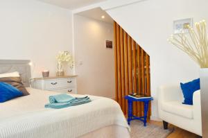 リスボンにあるAlfacinha - Checkinhomeのベッドルーム(白いベッド1台、白い椅子付)