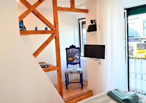リスボンにあるAlfacinha - Checkinhomeの階段、テレビ、椅子が備わる客室です。