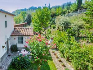 widok na ogród z kwiatami i dom w obiekcie Apartment Il Gelsomino by Interhome w mieście La Collina