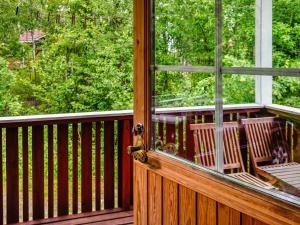 une terrasse couverte en bois avec une fenêtre et des chaises. dans l'établissement Holiday Home Nokikana 7 by Interhome, à Strandby
