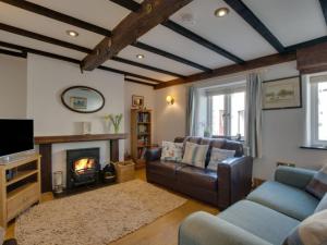sala de estar con sofá y chimenea en Holiday Home Spop by Interhome en Wadebridge