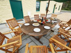 a wooden table and chairs on a patio at Holiday Home Ty Llan by Interhome in Llanwrtyd