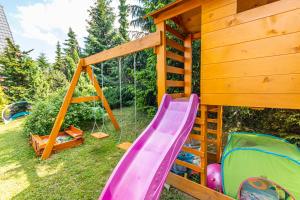 a playground with a slide and a play house at Willa Natura in Gliczarów