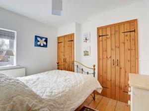 East RudhamにあるHoliday Home 18 The Green by Interhomeのベッドルーム1室(ベッド1台、木製のドア付)