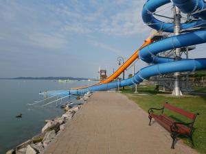 a water slide in a park next to the water at Balaton Exclusive Apartman in Csopak