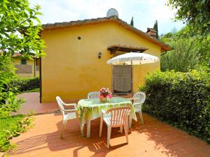 una mesa y sillas en un patio con una casa amarilla en Holiday Home Villetta La Ginestra by Interhome, en La Collina