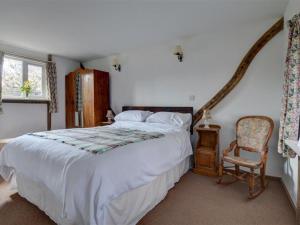 BiddendenにあるHoliday Home Bisho by Interhomeのベッドルーム(大型ベッド1台、椅子付)