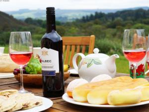 a table with a bottle of wine and wine glasses at Holiday Home Ty Llan by Interhome in Llanwrtyd