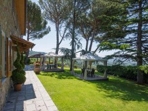 a garden with tables and gazebos on the grass at Apartment Giglio by Interhome in San Baronto