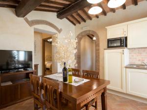 una cocina con una mesa con una botella de vino. en Apartment Giglio by Interhome, en San Baronto