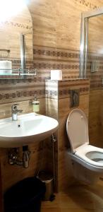 a bathroom with a white sink and a toilet at Apart Hotel Iglika in Pomorie