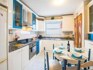 a kitchen with white cabinets and a table with chairs at Apartment Mariners 2 by Interhome in Alcudia