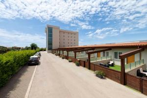 un edificio con auto parcheggiate sul lato di una strada di Simon Hotel a Pomezia