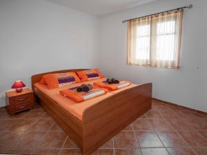 una camera da letto con un letto con cuscini arancioni e una finestra di Apartment Josipa-3 by Interhome a Klenovica Altre 24 foto