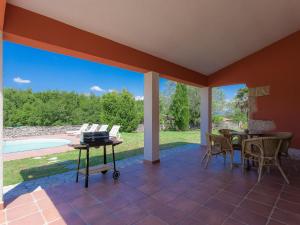 un patio con mesa, sillas y piscina en Holiday Home Roberto by Interhome, en Trgetari
