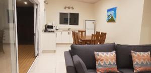 sala de estar y cocina con sofá y mesa en Te Etu Villa 1, en Rarotonga