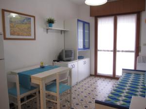a small room with a table and chairs and a tv at Appartamento Franco in Grado
