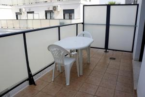 a white table and two chairs on a balcony at Apartamento en Oliva Nova junto a la playa y MET in Oliva