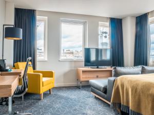 a hotel room with a bed and a tv and a couch at Apex Waterloo Place Hotel in Edinburgh