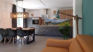 kuchnia i jadalnia ze stołem i krzesłami w obiekcie Alpen Appartements Viehhofen - incl Sommercard Zell am See Viehhofen w mieście Viehhofen