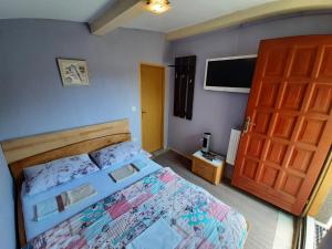 a bedroom with a bed and a wooden door at Restoran i sobe "Tocak" in Doboj
