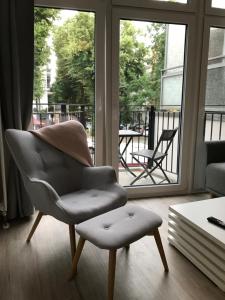 uma cadeira sentada numa sala de estar ao lado de uma janela em Apartmenthaus Hamburg Eppendorfer Weg em Hamburgo
