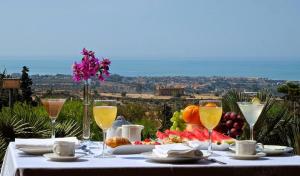 a table with food and wine glasses and a view at Colleverde Park Hotel in Agrigento