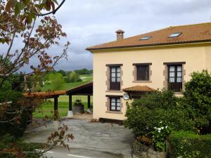 Una casa grande con un patio enfrente. en Posada La Pedriza, en Pontones