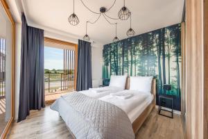ein Schlafzimmer mit einem großen Bett und einem großen Fenster in der Unterkunft Resorts Kołobrzeg, Sun & Snow in Kołobrzeg