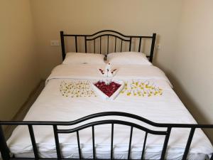 a bed with a white bedspread with a heart on it at Glisura Apart in Uzungol